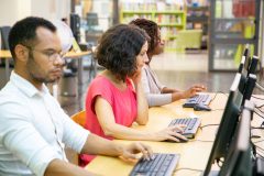 diverse-adult-students-working-computer-class-min-scaled